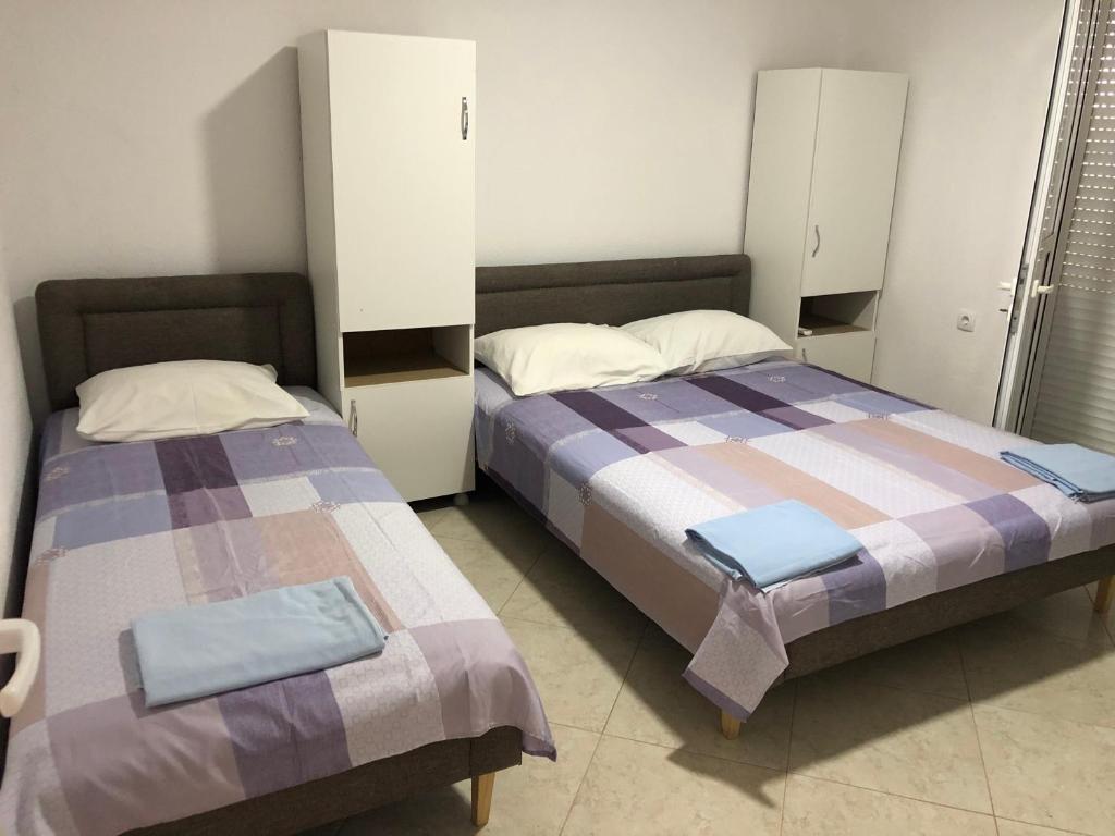duas camas sentadas uma ao lado da outra num quarto em Apartments Beho em Ulcinj