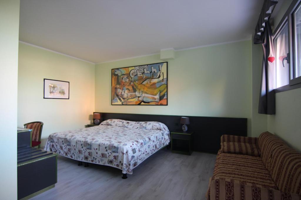 1 dormitorio con 1 cama y 1 sofá en Green Hotel, en Poviglio