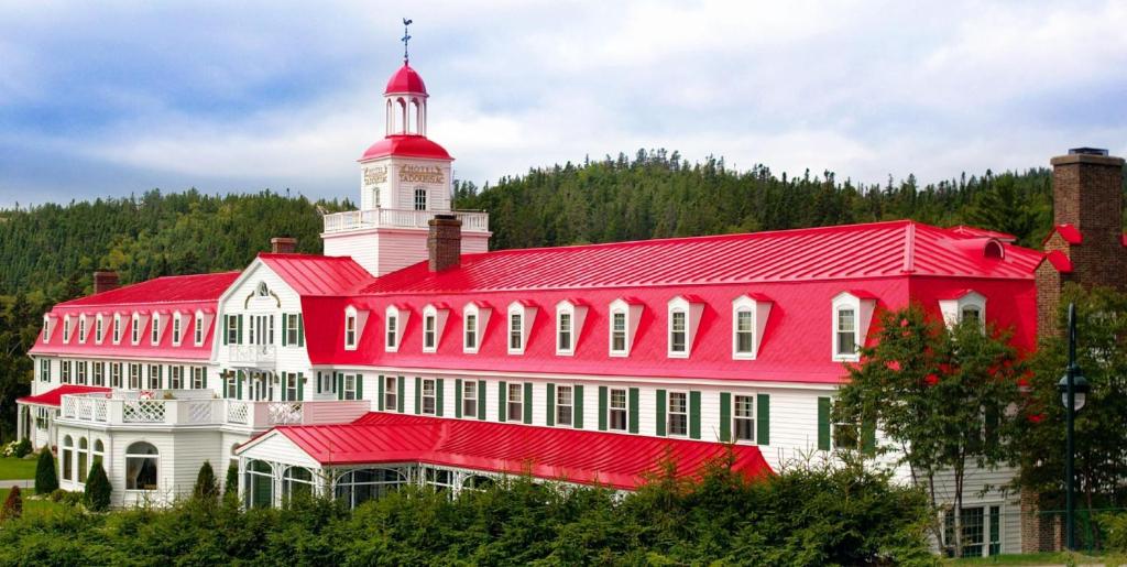 a large red and white building with a tower at Hotel Tadoussac in Tadoussac