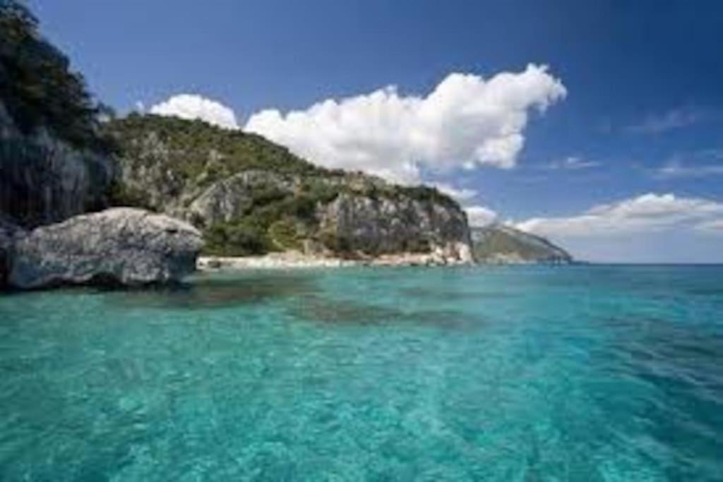 a large body of water with a rocky island at Casa in campagna Su Frassu in Monti