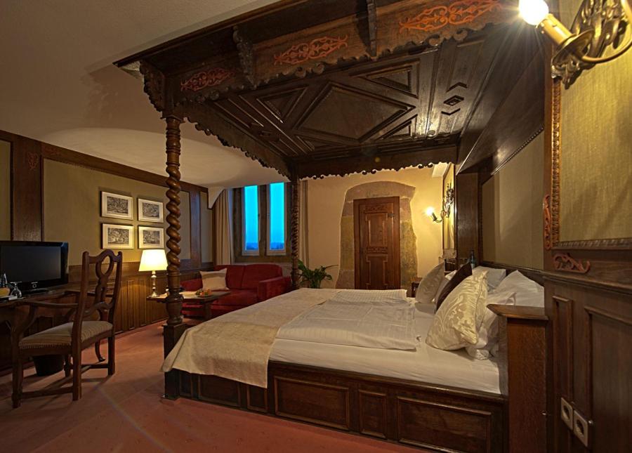 a bedroom with a large bed with a wooden canopy at Hotel Stadtpalais in Lemgo