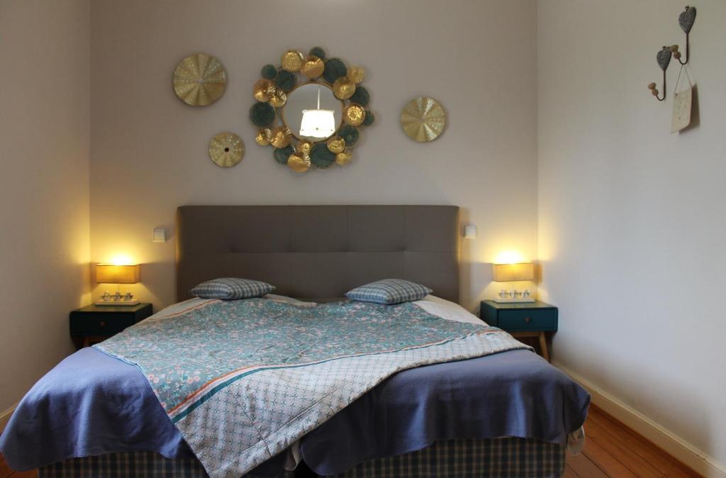 - une chambre dotée d'un lit avec 2 lampes et des horloges murales dans l'établissement Aux Berges de la Thur, à Staffelfelden