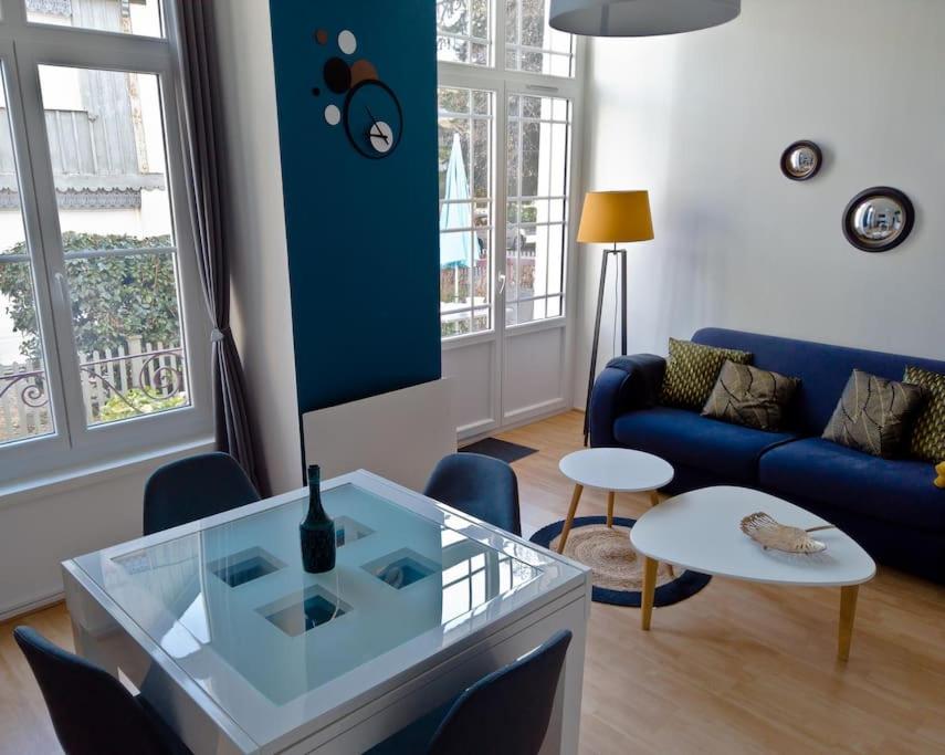 a living room with a blue couch and a table at Le Ginkgo biloba in Luchon