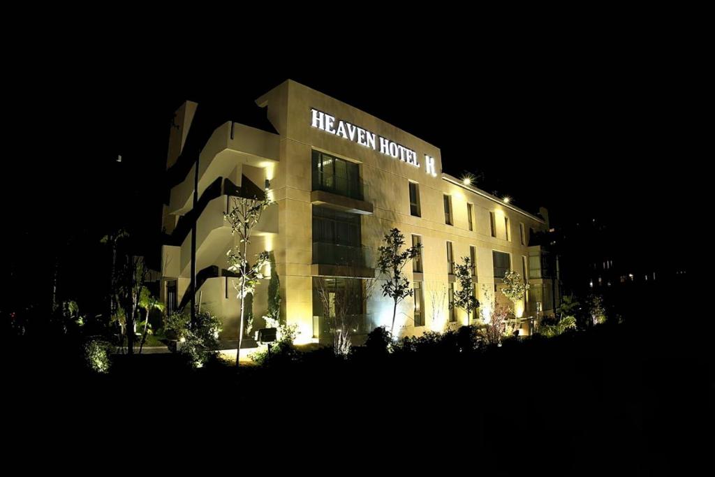 朱尼耶的住宿－Heaven Prestige Hotel，一座建筑,晚上有哈拉里世界的标志