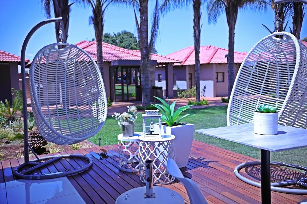 Un patio con dos sillas y una mesa en una terraza. en Ultimate Sky-3 bedroom villa, en Pretoria