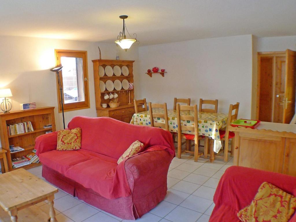 a living room with a red couch and a table at Appartement 4 pièces au coeur de Samoëns - Résidence Les Grandes Alpes - FR-1-629-87 in Samoëns