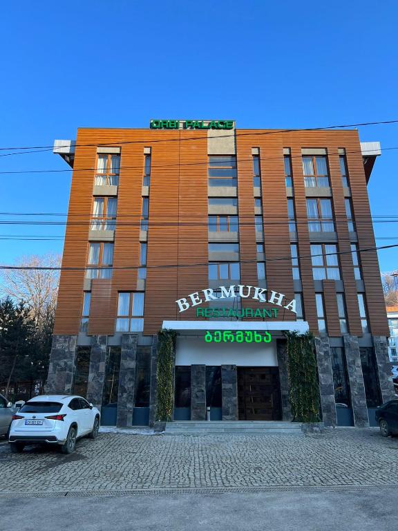 a building with a car parked in front of it at Bakuriani Orbi Palace in Bakuriani