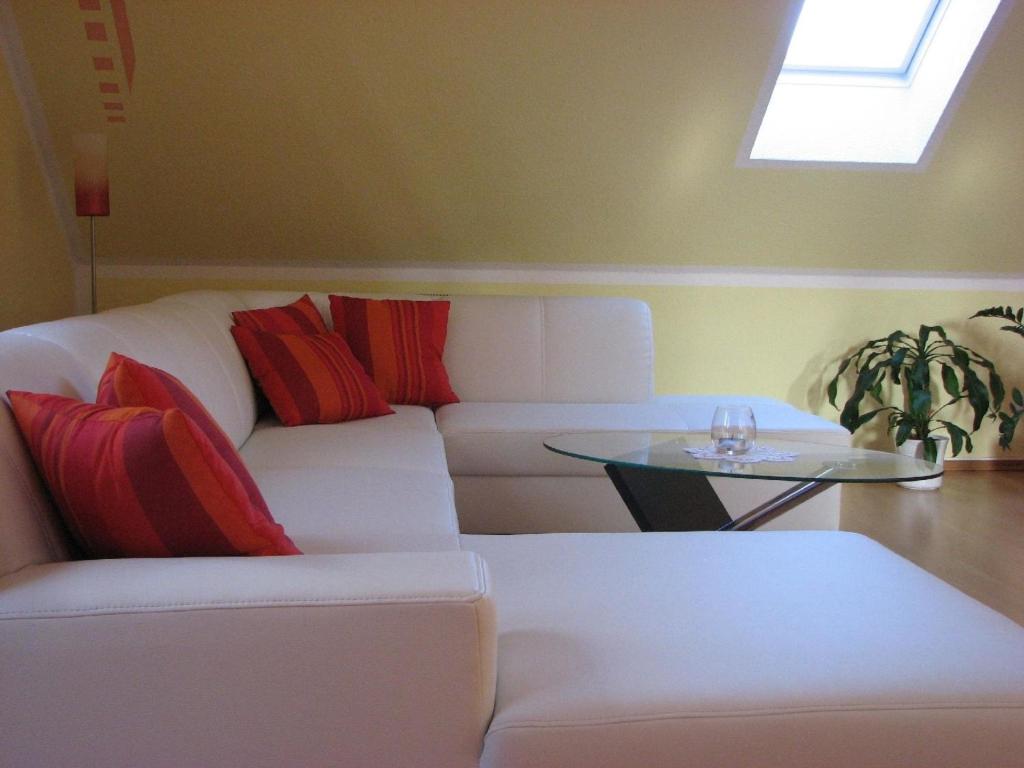 uma sala de estar com um sofá branco e uma mesa em Komfortable Ferienwohnung mit Balkon und Blick in den Schlosspark 