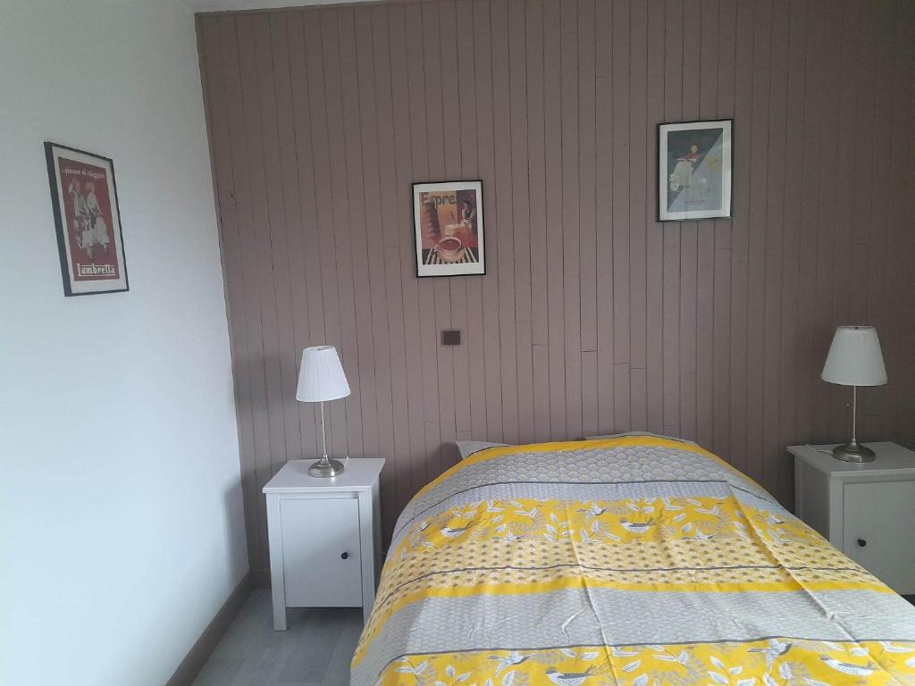 a bedroom with a bed and two night stands with lamps at Gîte Linglet in Fumay