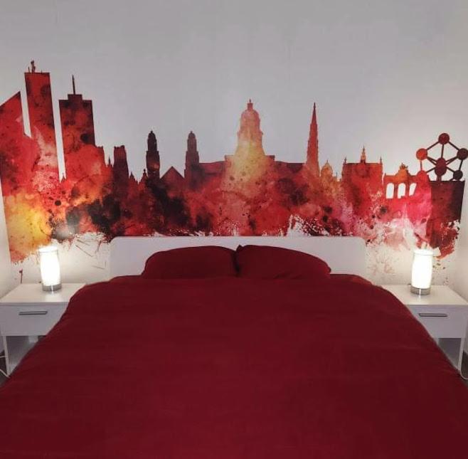 a bedroom with a red bed with a city skyline at BRUSSELS EXPO APARTMENT in Brussels