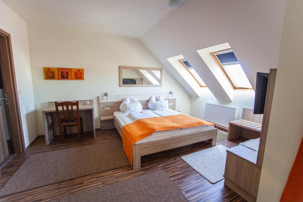 1 dormitorio con 1 cama, escritorio y ventanas en Azúr Ház Kamilla Apartman, en Sárvár