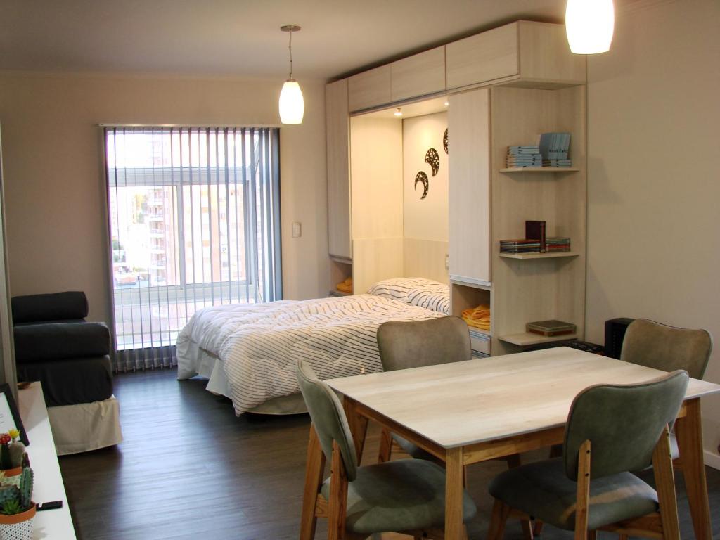 sypialnia z łóżkiem, stołem i krzesłami w obiekcie Departamento Rivadavia w mieście Santa Rosa