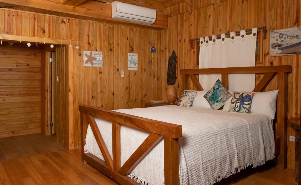 a bedroom with a bed in a wooden cabin at Hotel Sea Breeze in Paraíso