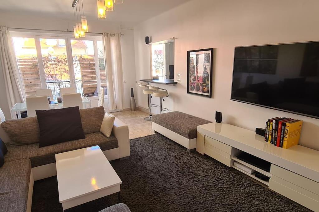 un salon avec une grande télévision à écran plat dans l'établissement CENTRE, 3P/TERRASSE , 300 m PLAGES., à Cannes
