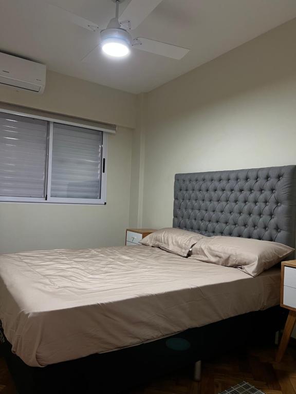 1 dormitorio con 1 cama grande y cabecero en Temporario Rosario Pellegrini en Rosario