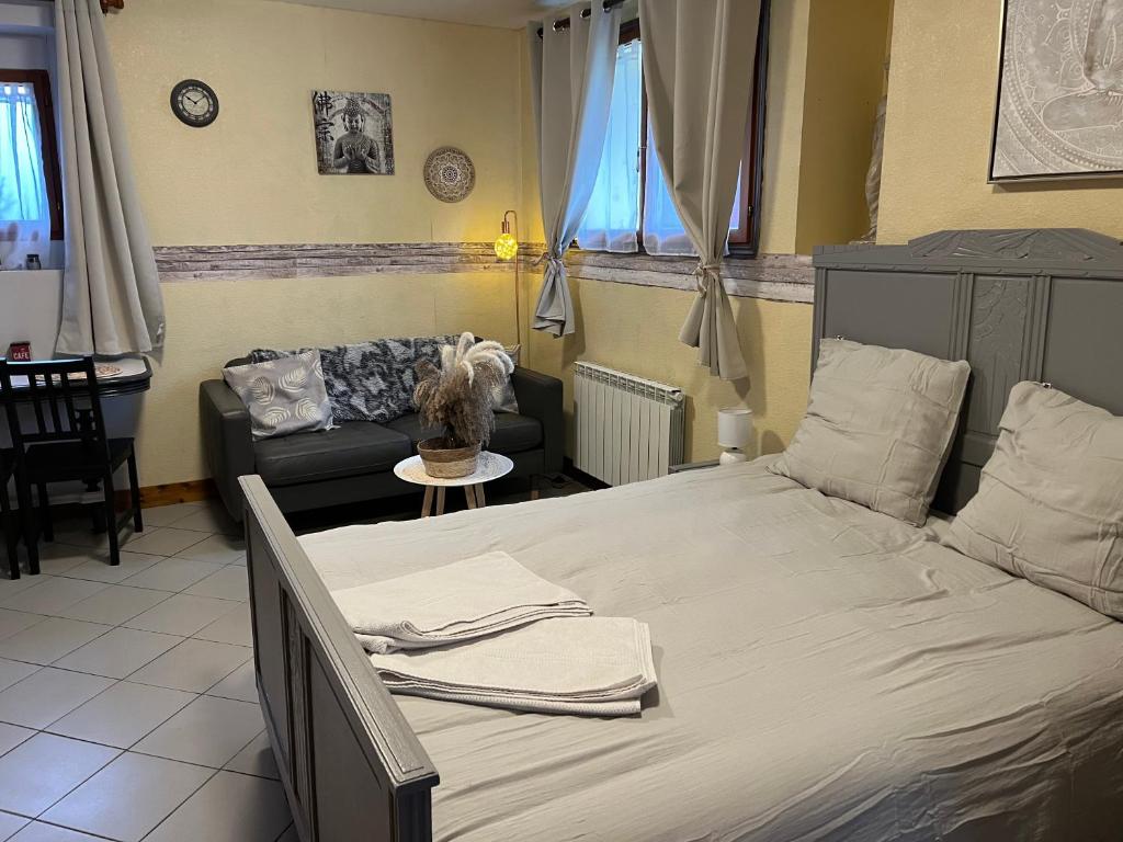 une chambre avec un lit et un canapé dans l'établissement LE PETIT ZEN, à Froberville