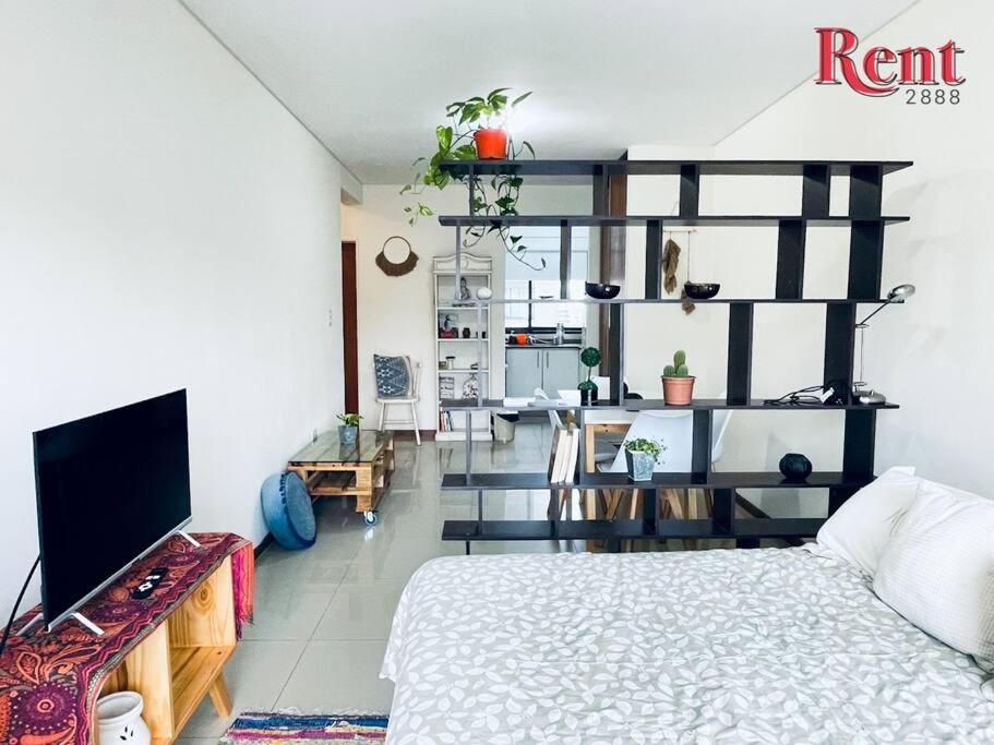 1 dormitorio con 1 cama y TV en una habitación en Rent Corrientes y Lambaré en Buenos Aires