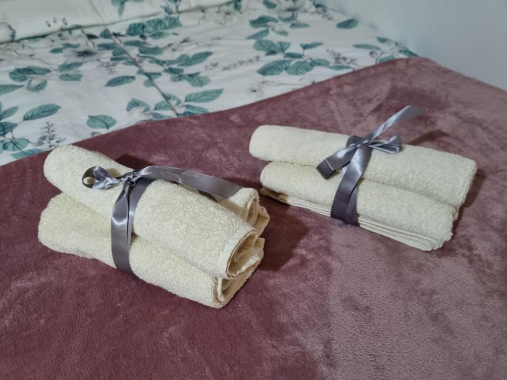 two rolled towels with a bow on a bed at Moon Bijeljina - stan na dan in Bijeljina