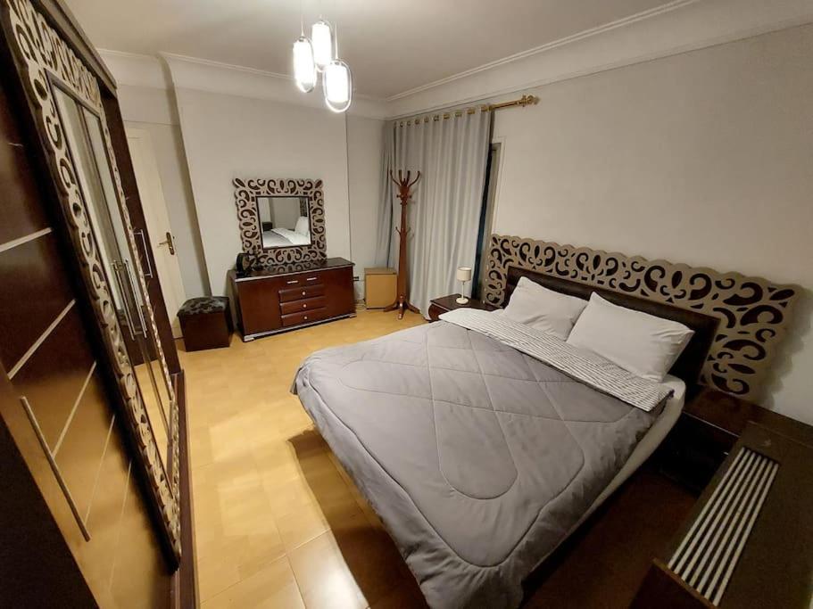 a bedroom with a bed and a dresser and a mirror at Room 2 in Cairo