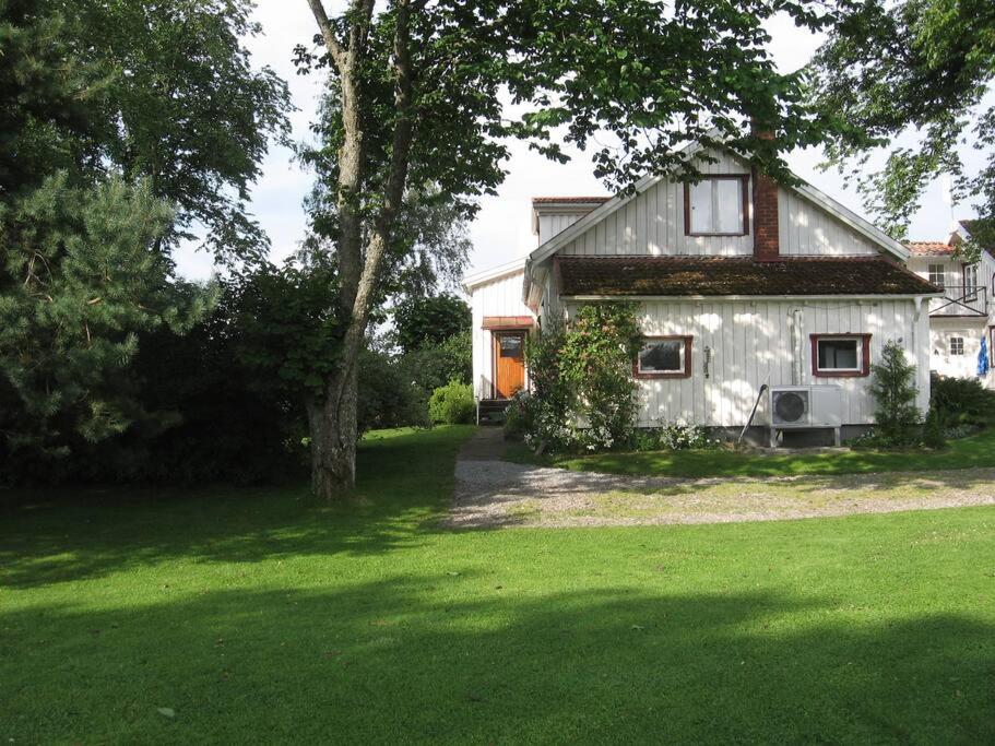 ein Haus in einem Garten mit grünem Rasen in der Unterkunft Vesteby Hus - a peaceful stay in the countryside! in Grästorp