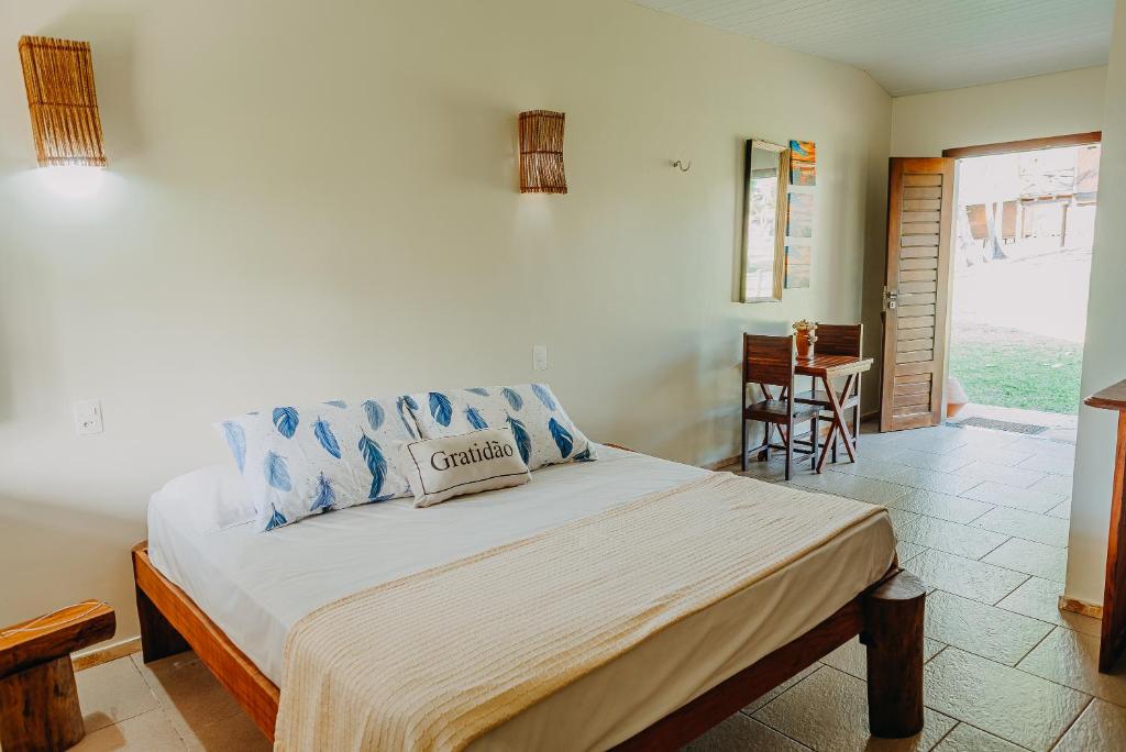 a bedroom with a large bed with blue pillows at Villa Baleia 