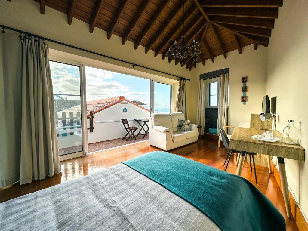 a bedroom with a bed and a large window at Matriz Guest House in Ribeira Grande