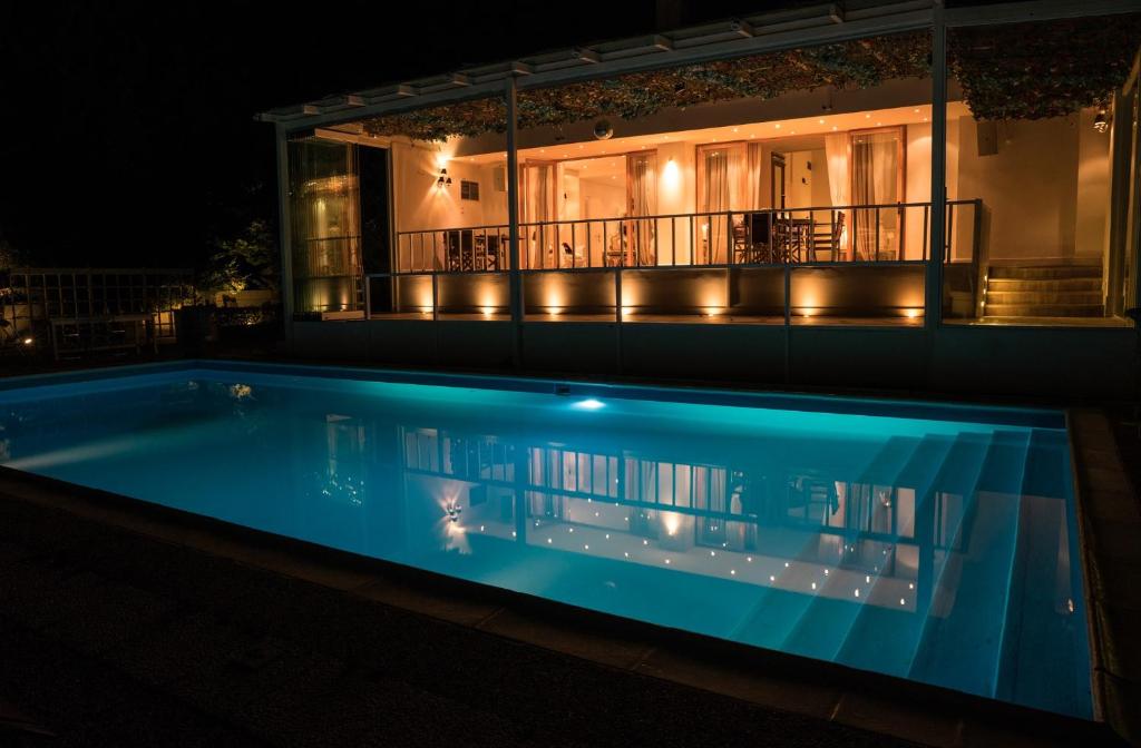 a swimming pool in front of a house at night at Ranch Ekru in Ánoixis