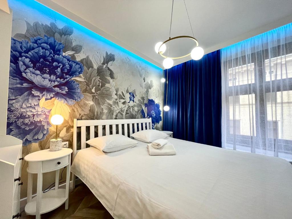 1 dormitorio con cama blanca y pared de flores en BelleView Apartment, en Toruń