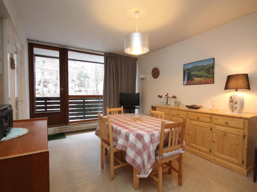 une salle à manger avec une table et des chaises et une fenêtre dans l'établissement Charmant T2 avec balcon exposé Ouest, parking privé, au Mont-Dore, proche centre et Thermes - FR-1-608-190, à Le Mont-Dore