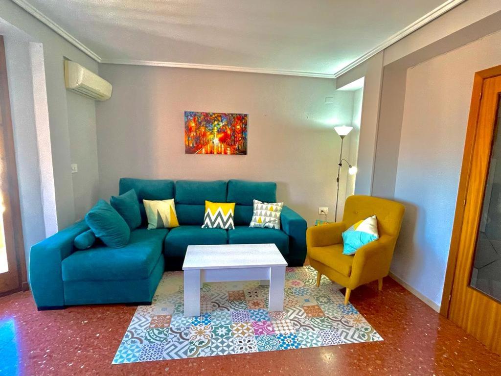 a living room with a blue couch and a table at Apartamento La Zahora - Alcañiz in Alcañiz