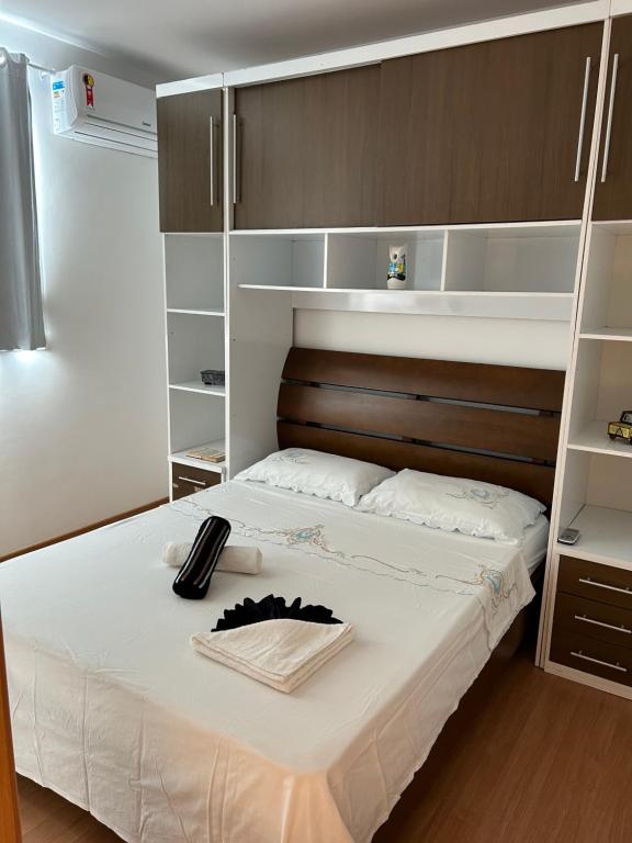 1 dormitorio con 1 cama con sábanas blancas y estanterías en Jardim da Costa perto da Praia e UFPB, en João Pessoa