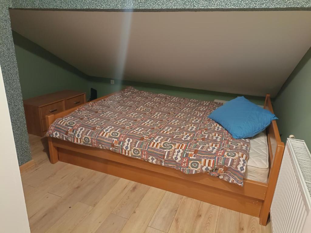 a bed with a blue pillow on top of it at Stan na dan Bijeljina in Nova Mahala