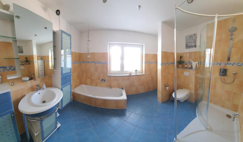 a bathroom with a tub and a sink and a shower at Ferienwohnung Teufelsmauer in Timmenrode