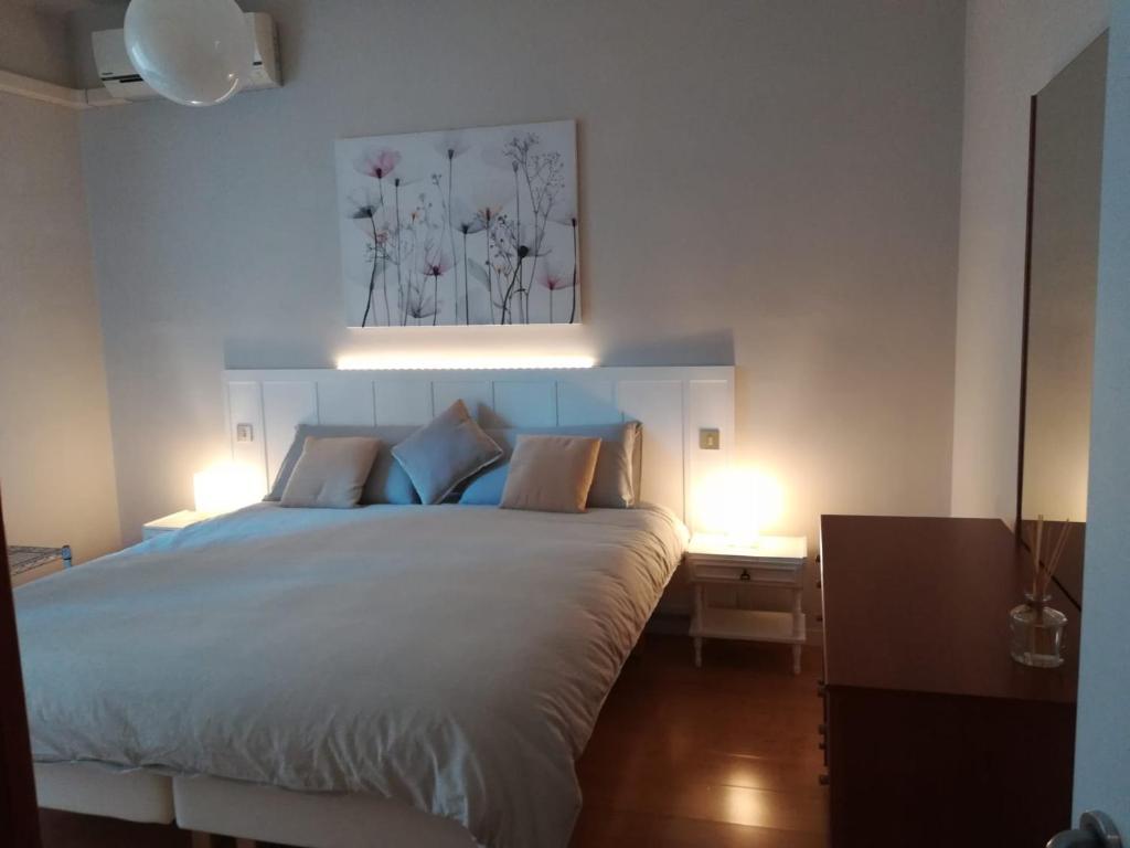 a bedroom with a large bed with two lights on it at PRIMO PIANO - Bilocale Casa Vacanze Brescia in Brescia