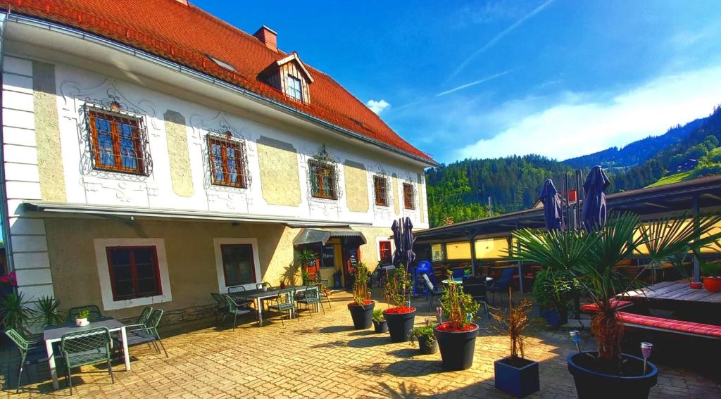 a courtyard with potted plants in front of a building at Gasthof Altes Hammerherrenhaus in Übelbach