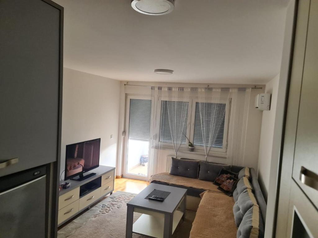 a living room with a couch and a tv at Apartman Jaca in Tuzla