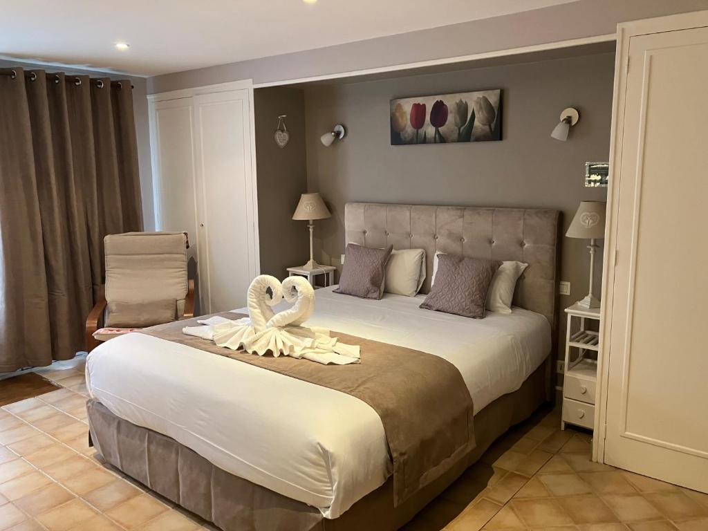 Un dormitorio con una cama grande con una toalla. en Hôtel de la Côte Fleurie, en Deauville