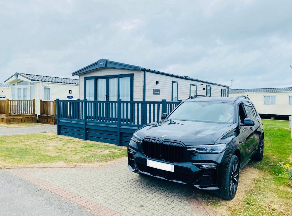 a black suv parked in front of a tiny house at Prime Location Selsey Chalet Seal Bay in Selsey