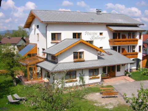 ein großes weißes Haus mit in der Unterkunft Hotel-Pension Stallinger in Weyregg