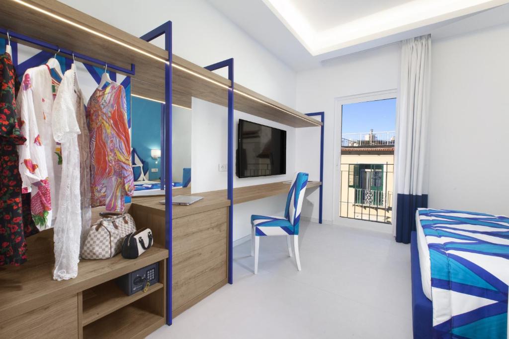 a bedroom with a bed and a desk and a tv at AMORE RENTALS - Appartamento Luis 2 11 in Sorrento