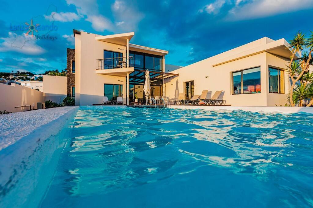 uma villa com piscina em frente a uma casa em Vivienda Vacacional Casa Erizo adults only em Nazaret