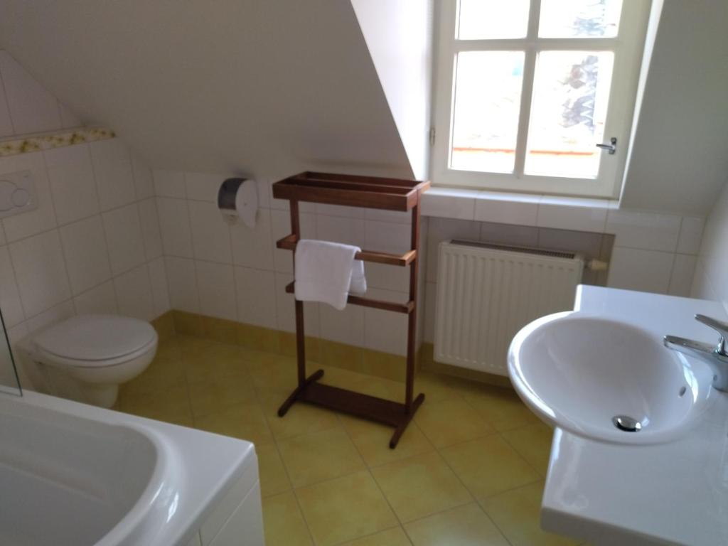 a bathroom with a sink toilet and a window at Penzion Joštovka in Jihlava