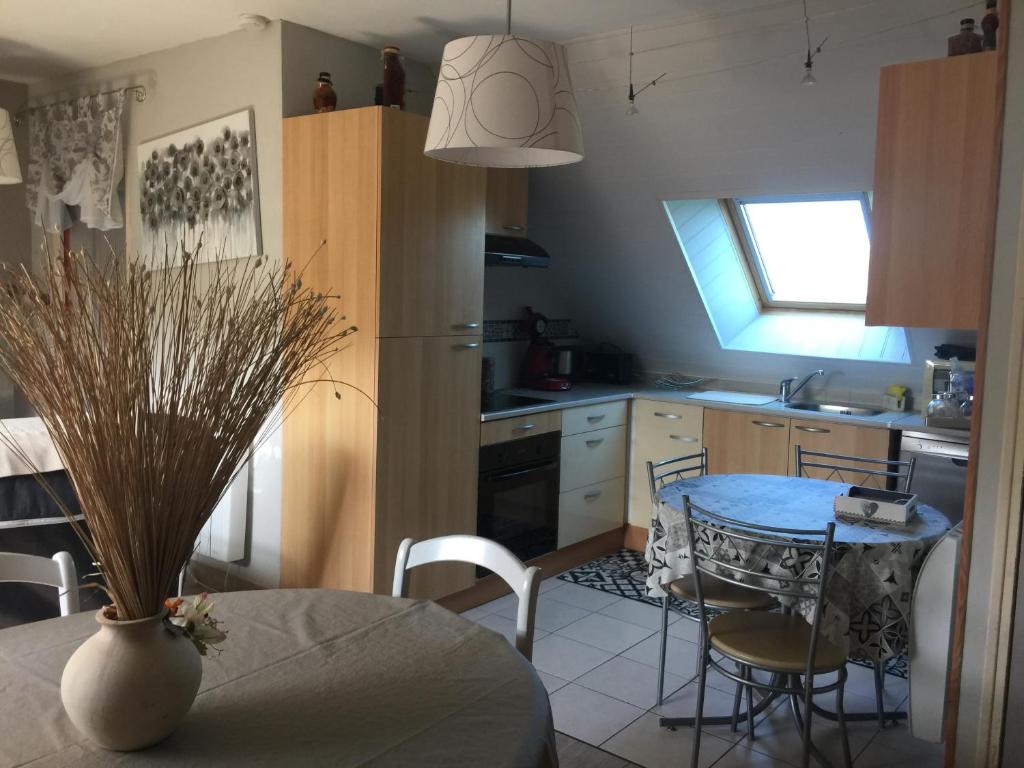 a kitchen with a table and a vase on a table at Le Cosy in Lanvallay