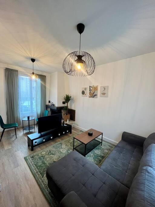 een woonkamer met een bank en een tafel bij Super appartement chaleureux à 30min de Paris in Gagny