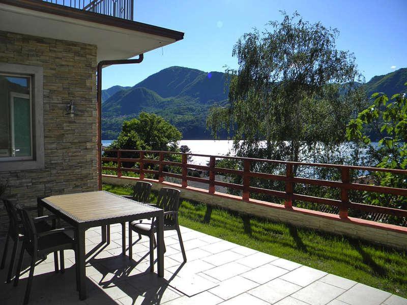 una mesa y sillas en un patio con vistas al lago en Casa Simone, en Omegna