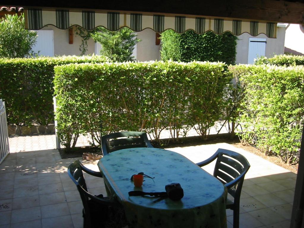 une table avec un oiseau assis en haut dans l'établissement MAISONS DU GOLF Joli villa mitoyenne proche plage Richelieu Cap d'Agde, au Cap d'Agde