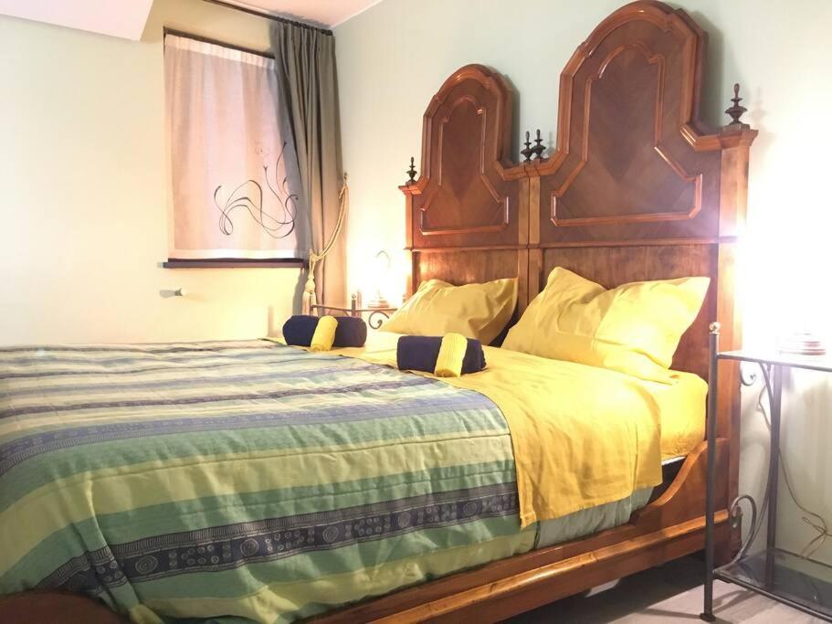 1 dormitorio con 1 cama grande y cabecero de madera en KOCIA, rifugio di pace in centro, en Gorizia