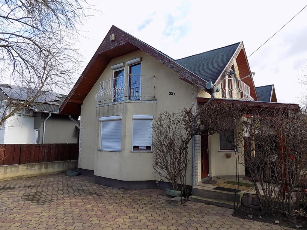 Casa blanca con balcón en la entrada en Gajó Kisduna Magánház, en Dunavarsány