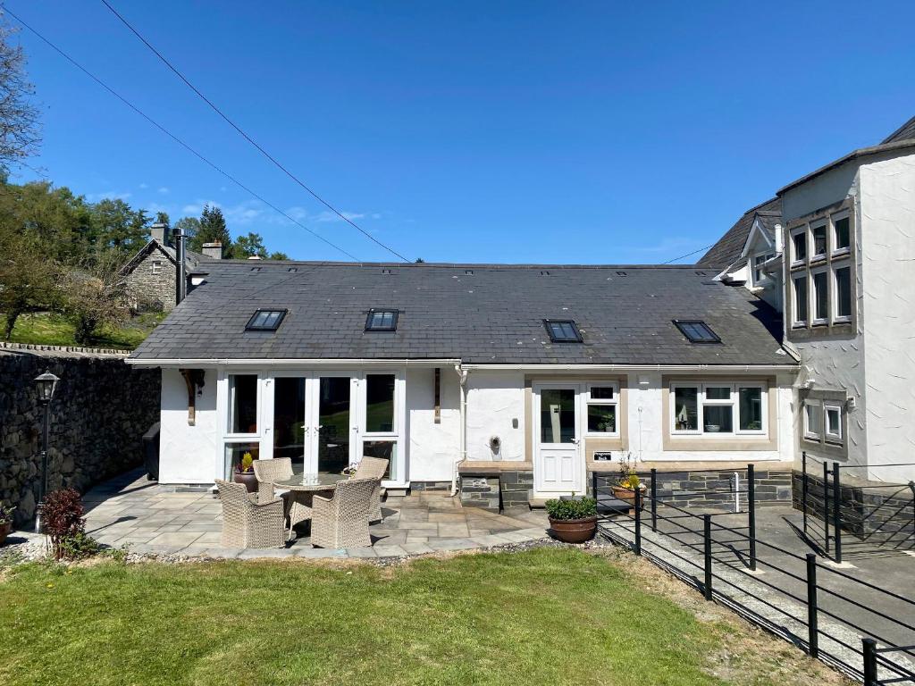 a white house with a patio with a table at Pengwern Bach in Llanrwst