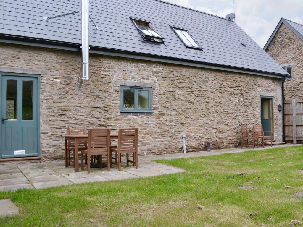 a table and chairs in front of a brick building at The Buttery - RFFO in Fownhope